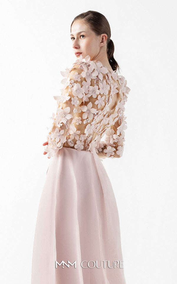 MNM Couture Style G2035 showcasing a blush pink gown with sheer illusion bodice, long sleeves adorned with 3D floral appliques, lace inserts, and flowing envelope skirt | Couture Shop LA