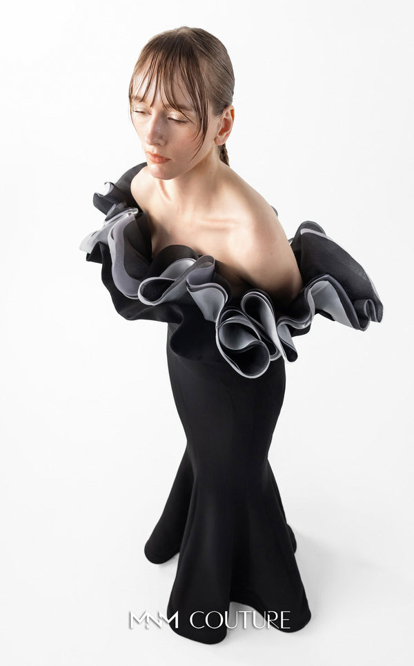 MNM Couture Style G2036 showcasing a black off-shoulder mermaid gown with long sleeves and voluminous, sculptural organza ruffles in silver, off-white, and anthracite. | Couture Shop LA