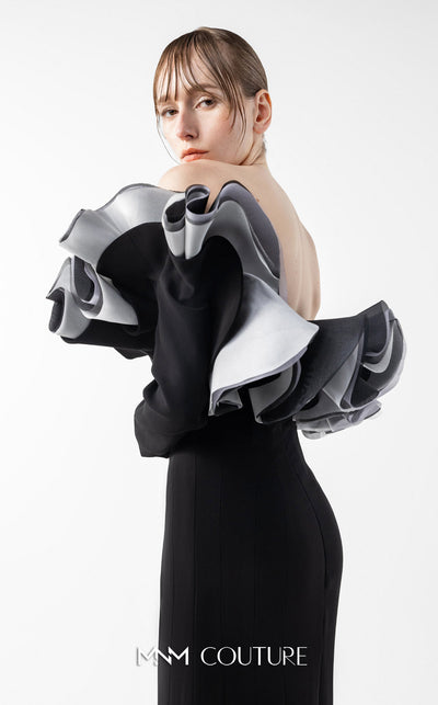 MNM Couture Style G2036 showcasing a black off-shoulder mermaid gown with long sleeves and voluminous, sculptural organza ruffles in silver, off-white, and anthracite. | Couture Shop LA