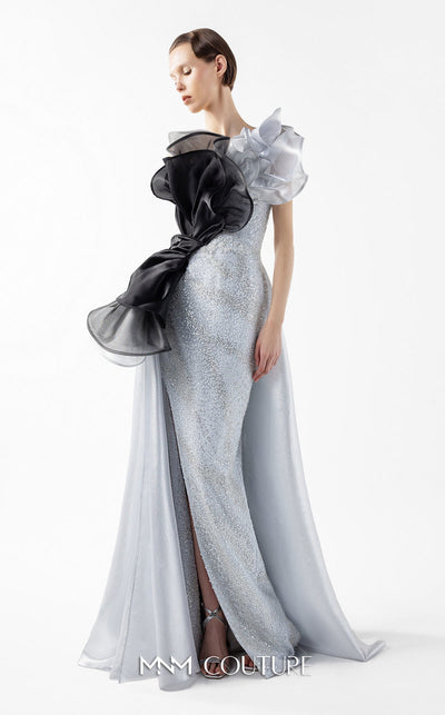 MNM Couture Style G2042 showcasing a silver lace gown with sculptural black and silver lamé organza ruffles, one-shoulder detail, and a high slit. | Couture Shop LA
