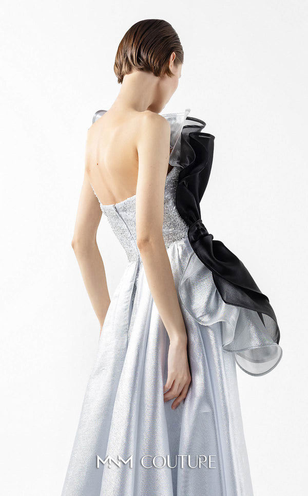 MNM Couture Style G2042 showcasing a silver lace gown with sculptural black and silver lamé organza ruffles, one-shoulder detail, and a high slit. | Couture Shop LA