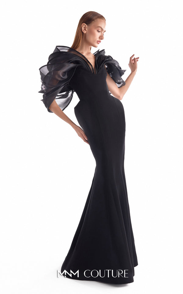 Black crepe mermaid gown MNM Couture Style G2110 with sculpted hips and voluminous blooming organza shoulders framing a V-neckline