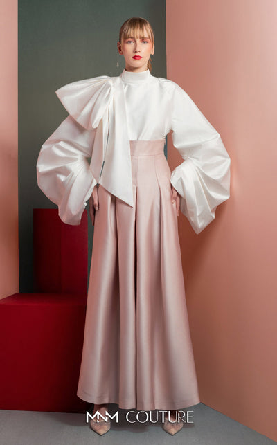 MNM Couture GOF2523 two-piece ensemble, featuring a white taffeta blouse with dramatically oversized sleeves and a front knot, paired with pink taffeta high-waisted, wide-leg pants. | Couture Shop LA