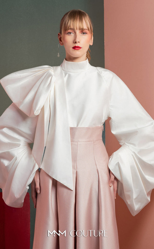 MNM Couture GOF2523 two-piece ensemble, featuring a white taffeta blouse with dramatically oversized sleeves and a front knot, paired with pink taffeta high-waisted, wide-leg pants. | Couture Shop LA