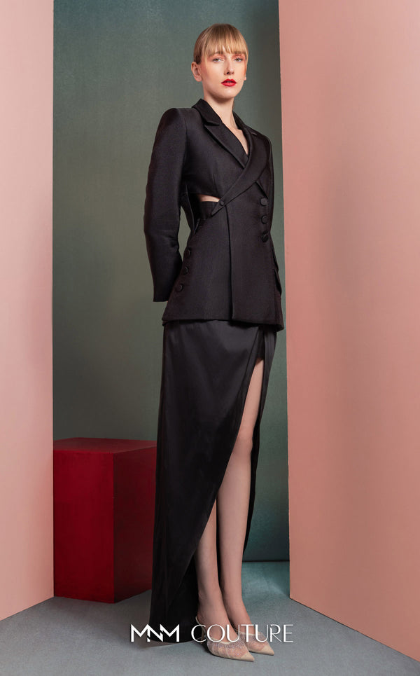 MNM Couture GOF2542 ensemble, with an asymmetrical black mikado piqué blazer featuring side cut-outs and button details, paired with a dramatic high-slit black taffeta skirt. | Couture Shop LA