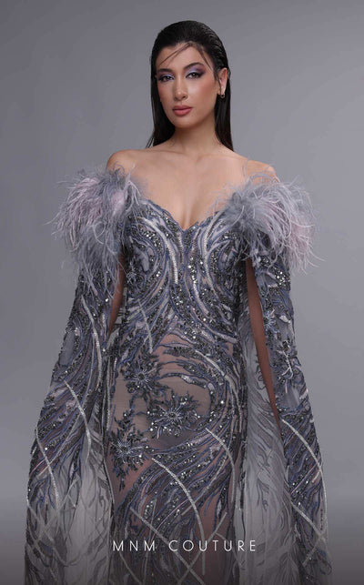 MNM Couture K4097 mermaid gown with sheer cape sleeves, feather details, and intricate beaded motifs. | Couture Shop LA