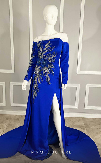 MNM Couture M1104 Fitted satin� off-shoulder gown adorned with� sequins� and� beads� in a flowery pattern with long sleeves, asymmetrical neckline, and high side slit. | Couture Shop LA