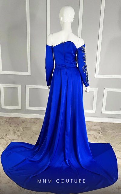 MNM Couture M1104 Fitted satin� off-shoulder gown adorned with� sequins� and� beads� in a flowery pattern with long sleeves, asymmetrical neckline, and high side slit. | Couture Shop LA