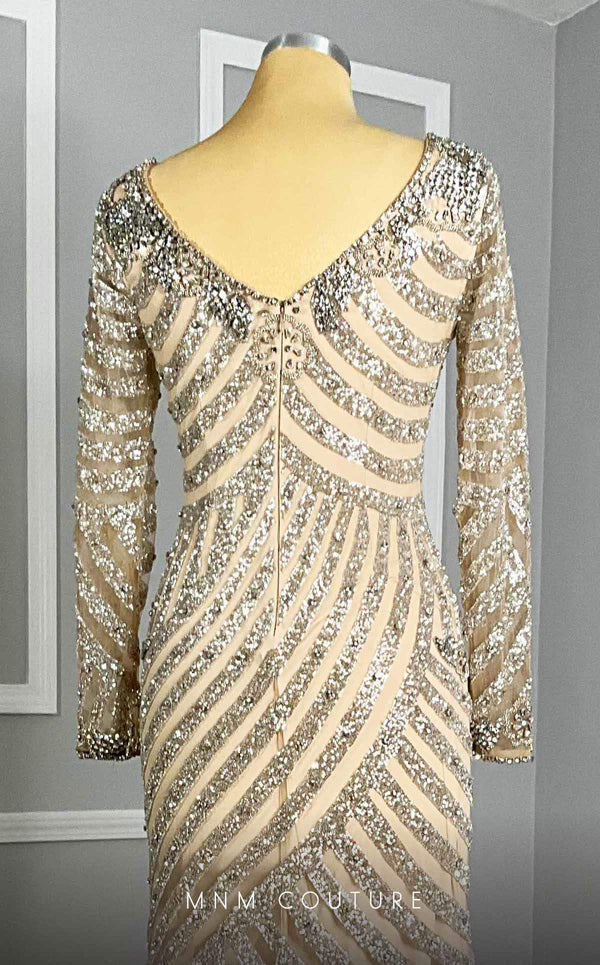 MNM Couture M1129 A stunning long dress from MNM Couture, featuring a fitted bodice, long sleeves, and a V neckline adorned with intricate beadwork and rhinestones. | Couture Shop LA