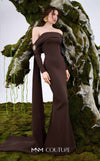 MNM Couture Style N0674 showcasing a brown fitted column gown with straight-across pleated neckline, long sleeves, asymmetrical design, flower brooch, and flowing train | Couture Shop LA