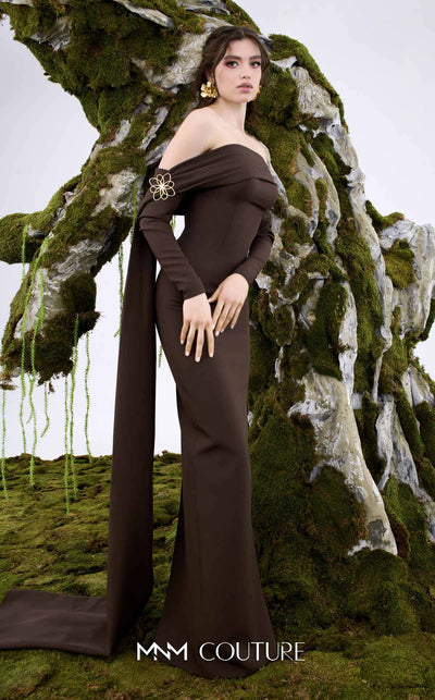 MNM Couture Style N0674 showcasing a brown fitted column gown with straight-across pleated neckline, long sleeves, asymmetrical design, flower brooch, and flowing train | Couture Shop LA
