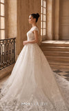 MNM Couture W2314 white off-shoulder ball gown wedding dress with structured flat shoulder drapes, pearl-beaded lace sweetheart bodice, 3D floral appliqués massed at the hem, corset lace-up back, and separate back overskirt with cathedral train | Couture Shop LA